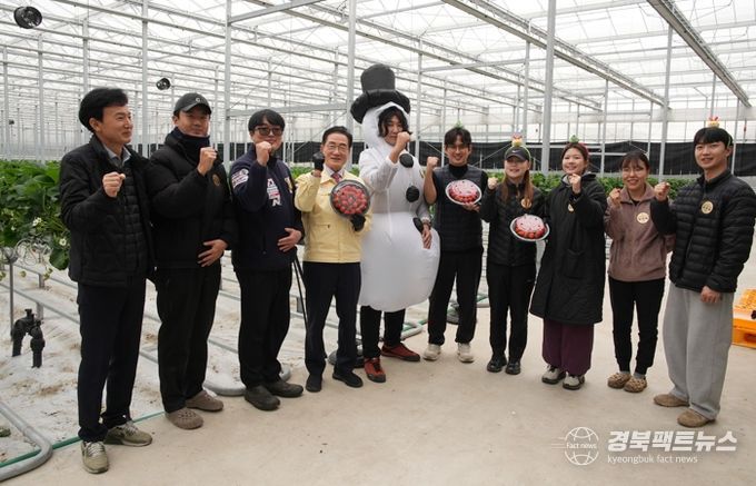 딸기 수확 현장에서 청년 농업인들과 시 관계자들이 기념 촬영을 하고 있다.